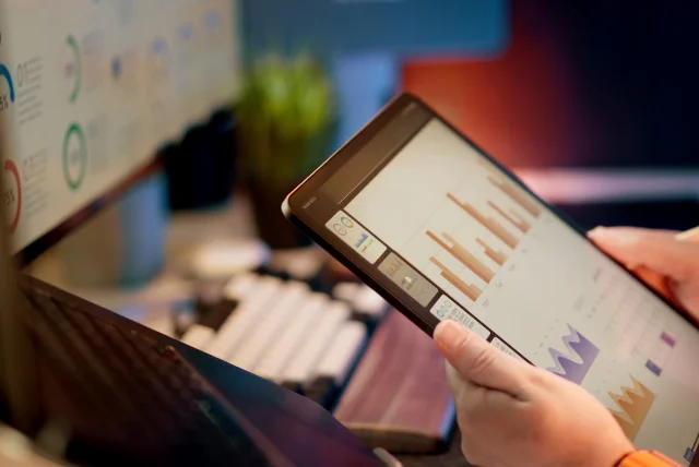 analyst reviewing charts on a tablet, showing how 7726 scam text reports are analysed