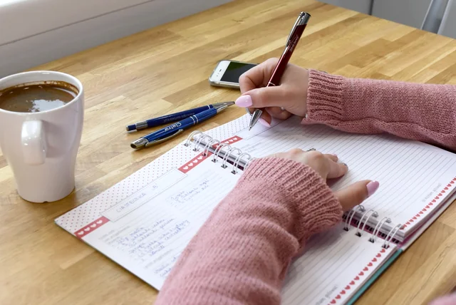 writing a timeline of a scam in a notebook before making a fraud report