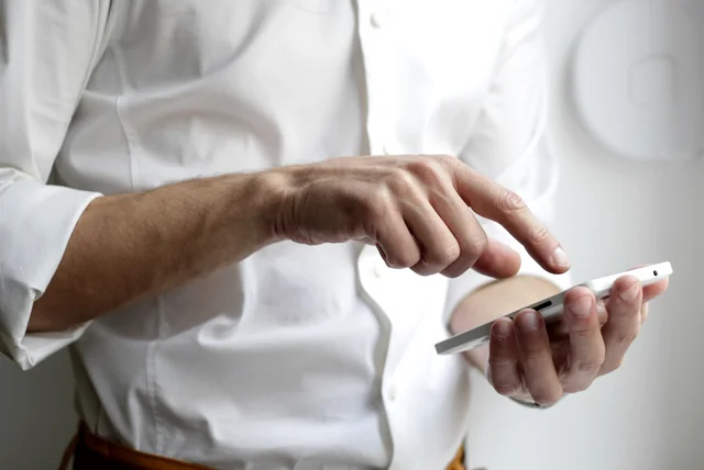 Hands holding a smartphone to view a driving record and penalty points online