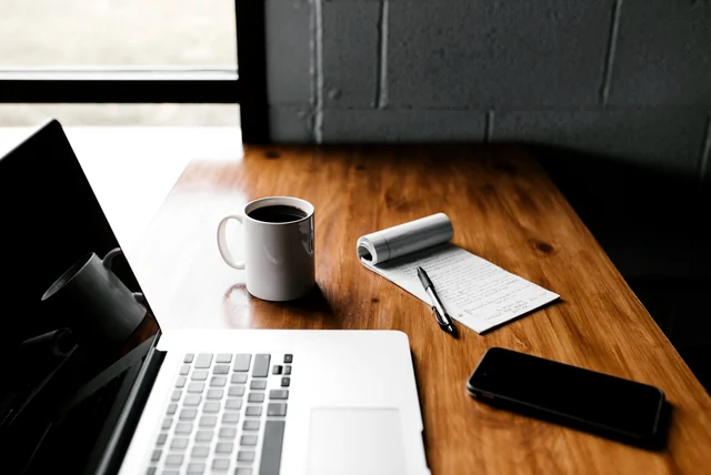 Laptop and mug on a desk, using the official GOV.UK View your driving licence service