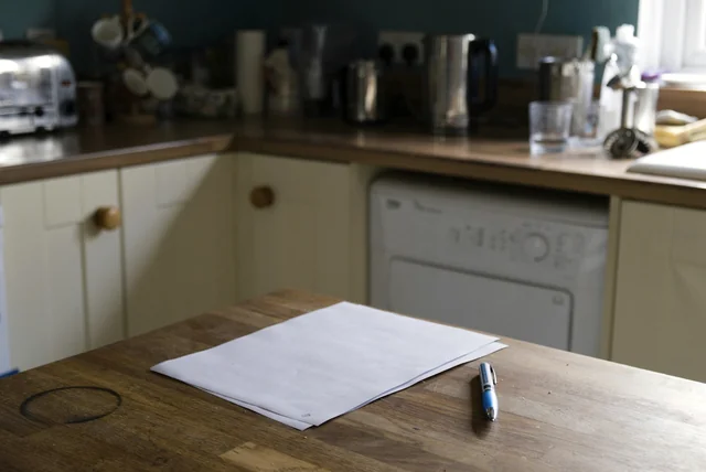Documents and a pen on a kitchen table, the details needed to sign in and check driving licence points