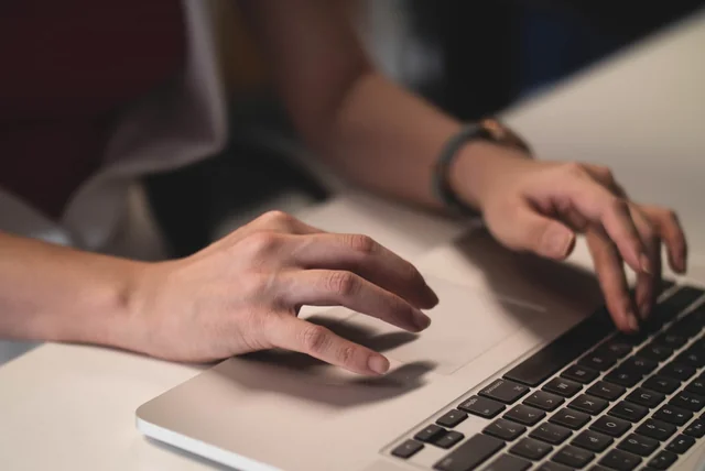Hands typing on a laptop to check driving licence points on the official GOV.UK service