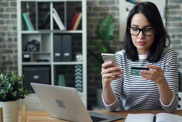Woman paying online with a bank card, choosing a payment method with buyer protection