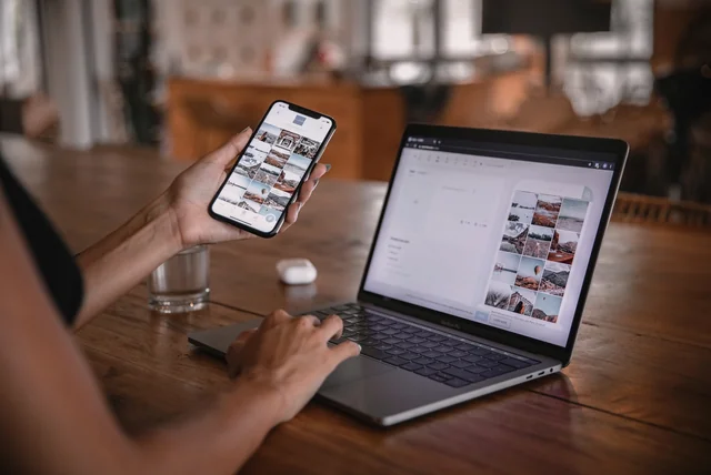 person checking their phone and laptop for updates and unfamiliar apps