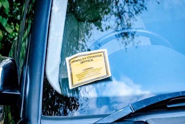 genuine yellow penalty charge notice fixed to a car windscreen