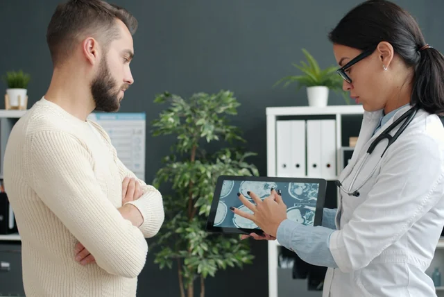 Doctor showing a patient a medical record on a tablet, like the planned single patient record