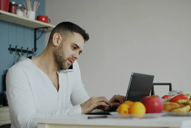 Man setting up an NHS login account on a laptop at his kitchen table