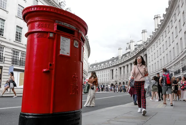 a red UK post box, a reminder to report fake Royal Mail and HMRC emails