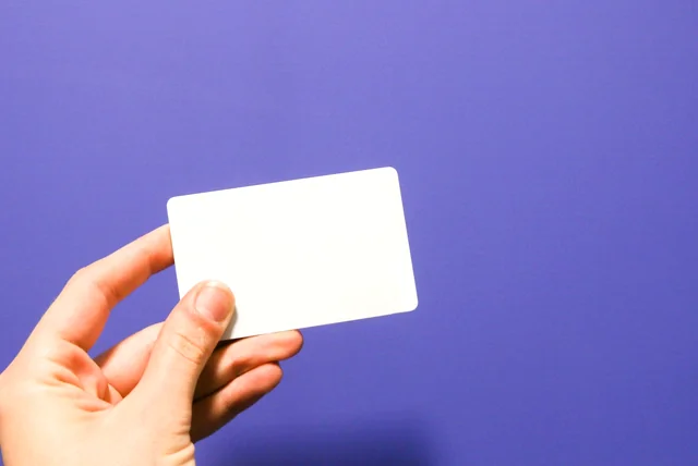 Hand holding a blank white card showing the UK has no compulsory digital ID card