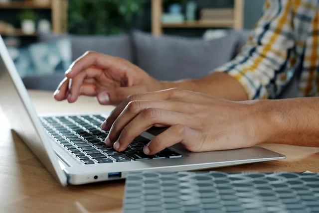 Person signing in to GOV.UK One Login on a laptop at home