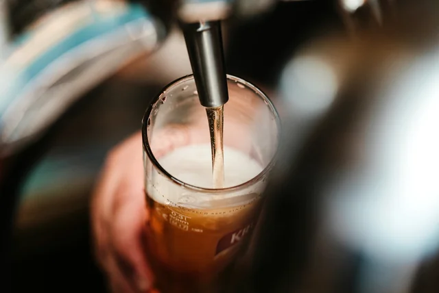 Pint being poured behind a bar after a digital right to work check